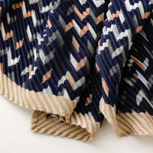 Detailed view of navy geometric pleated scarf with zigzag pattern and textured fabric