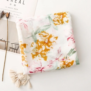 Close-up of cotton linen scarf with abstract floral prints and cream tassel charms