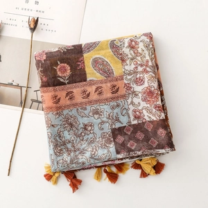 Détail d'une écharpe bohème à motifs paisley avec des pompons décoratifs