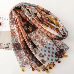 Détail d'une écharpe bohème avec motifs floraux, cachemire et pompons faits à la main