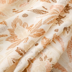 Detailed macro view of ethnic floral and feather print on beige soft fabric shawl