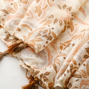 Detailed macro view of floral leaf print scarf with soft texture and brown tassels