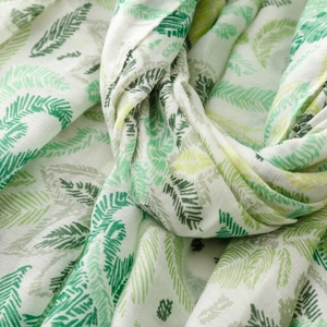 Detail of white scarf with green leaf print showing breathable soft fabric texture