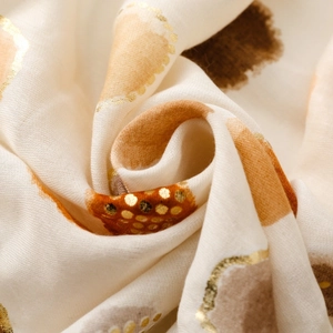 Detail of lightweight scarf fabric with gold foil heart dots and soft woven texture
