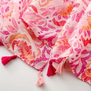Detailed close-up of paisley floral print scarf with soft pink and orange tassel edges