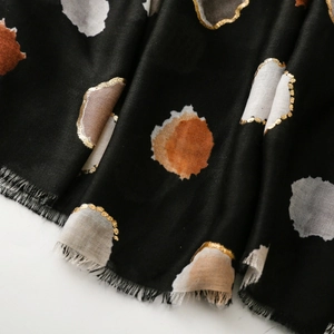 Close-up of black scarf featuring colorful dots with elegant gold foil metallic edges