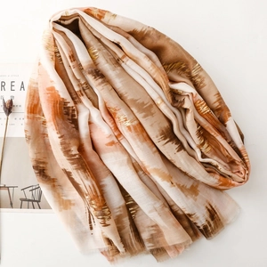 Detailed shot of artistically striped scarf with gold foil printing and fringe edge