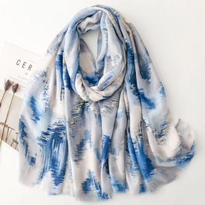 Artistic blue and white scarf with gold leaf stripes and soft frayed edges for travel