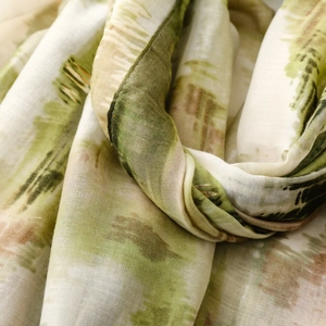Detailed macro view of artful landscape print on a soft olive and beige lightweight scarf