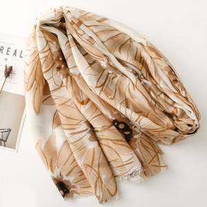 Close-up of lightweight floral scarf with daisy print and delicate fringe edges