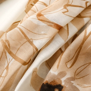 Detailed close-up of daisy floral print on translucent satin silk scarf fabric