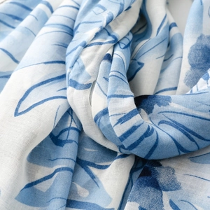 Detailed macro shot of blue daisy floral print on a lightweight satin texture scarf