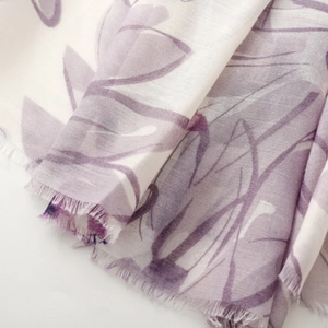 Detail of light purple floral scarf showing thin fabric texture and frayed fringe edge