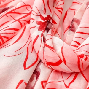 Close-up of pink satin floral scarf showing soft texture and artistic daisy pattern print