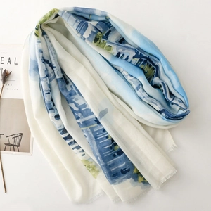 Close-up of blue and white watercolor silk scarf with soft fringe and smooth texture