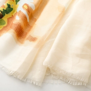 Detail of soft satin silk scarf featuring artistic abstract floral print and fringe edges