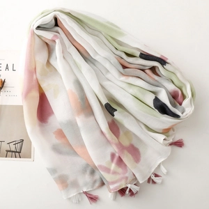 Close-up of colorful abstract floral scarf with pink tassels and soft cotton-linen feel