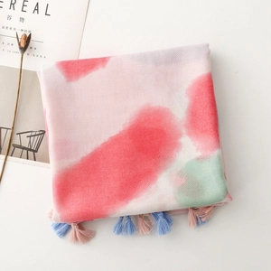 Detailed view of tie-dye scarf with pink and green floral print and soft fringe tassels