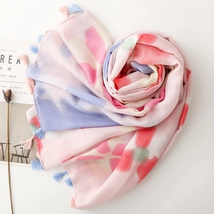 Detail of floral printed scarf with pastel watercolor patterns and colorful fringe edge
