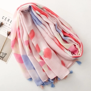 Close-up of pink cotton-linen scarf with colorful watercolor prints and tassel fringe