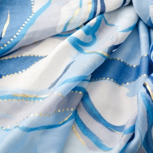 Detailed macro view of blue floral scarf with elegant gold foil stamping and silk texture