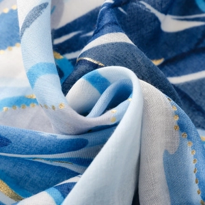 Macro detail of satin scarf featuring blue orchid prints and gold foil dots texture