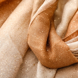 Détail d'une écharpe dégradée avec impression à la feuille d'or et texture douce