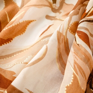 Macro detail of scarf featuring gold foil dots and floral leaf print texture