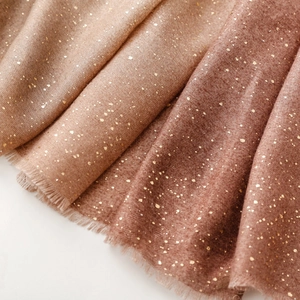 Détails d'un châle dégradé avec des touches de feuille d'or et bords effilochés