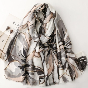 Elegant floral satin scarf with gold stamping and fringed edges on minimalist background