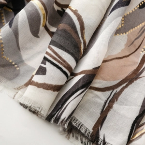 Detailed macro view of satin scarf with gold foil floral patterns and fringed edges