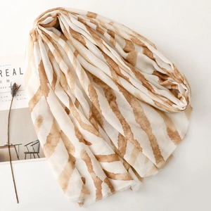 Detailed view of lightweight amber zebra print scarf with soft fringed edges on white