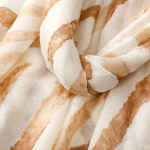 Detailed close-up of soft satin texture and amber zebra pattern on a thin scarf