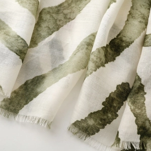 Close-up of soft lightweight scarf with olive green stripes and natural frayed fringe edges