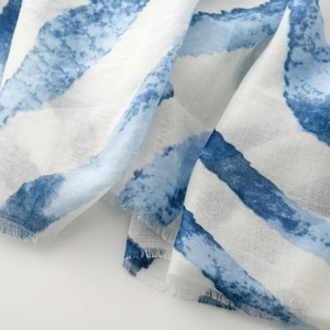 Detailed view of lightweight blue striped scarf fabric with soft frayed edges texture