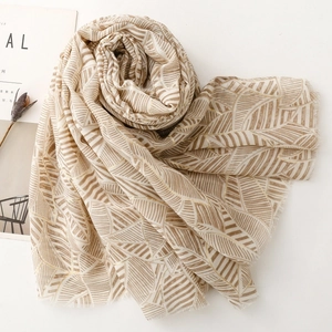 Close-up of lightweight leaf pattern scarf showing delicate fringed edges and satin texture
