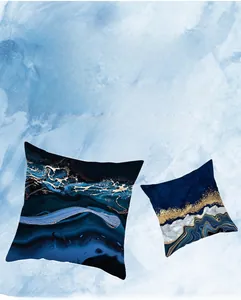 Détail des housses de coussin avec peinture à l'encre, feuilles d'or et dégradé bleu