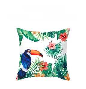 Macro shot of tropical toucan and floral print on soft peach skin fabric cushion cover