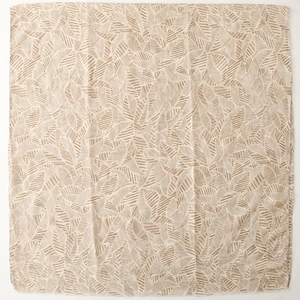 Flat lay of beige scarf with gold leaf pattern showing fabric texture and detail