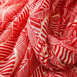 Macro shot of red and white leaf pattern scarf with elegant gold metallic leaf veins