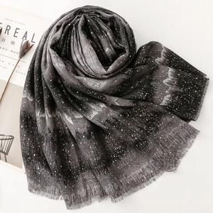 Close-up of black gradient cotton linen scarf featuring gold and silver starry foil patterns
