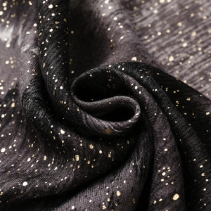 Macro view of black fabric with golden star bronzing pattern and soft texture