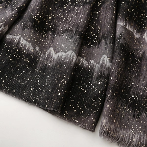 Close-up of thick satin cotton linen shawl with golden foil print and fringe detail