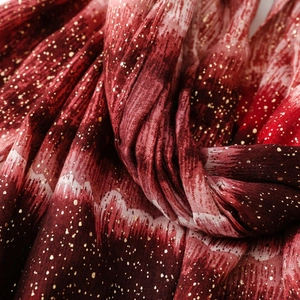 Detail of red gradient scarf with gold foil speckles and pleated cotton linen texture