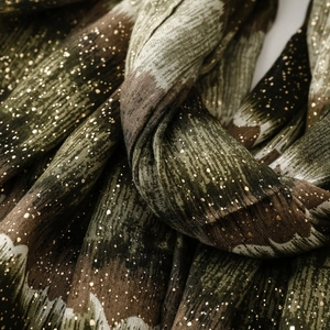 Macro shot of pleated camouflage scarf fabric with subtle gold foil flecks and soft texture
