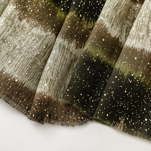 Close-up of gradient cotton linen scarf featuring gold glitter and frayed fringe edges