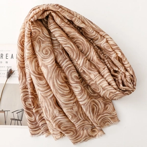 Vue détaillée de l'écharpe aux motifs de vagues latte avec bords effilochés et texture en lin