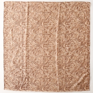 Gros plan d'une écharpe en coton et lin avec des motifs paisley vintage marron et crème
