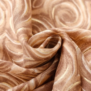 Macro d'un tissu d'écharpe marron à motifs de marbre avec des détails en fils dorés