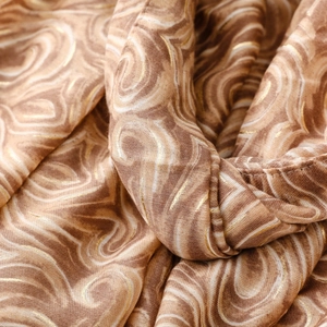 Détail macro de l'écharpe en coton-lin épais avec imprimé vagues dorées et texture
